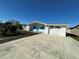 Charming one-story home featuring a white exterior, blue accents, a well-maintained yard, and a spacious driveway at 12613 4Th Isle, Hudson, FL 34667