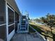 Backyard view of canal-front property with blue wood stairs to an upper deck for outdoor relaxation at 12613 4Th Isle, Hudson, FL 34667