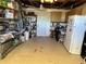 Functional garage space with ample storage shelves, lighting, and a refrigerator at 12613 4Th Isle, Hudson, FL 34667