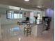 Spacious kitchen with island seating that opens into an airy living area with natural light and tile floors at 12613 4Th Isle, Hudson, FL 34667