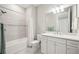 Bright bathroom featuring a shower over tub and a modern white vanity with ample storage at 13867 Vadini St, Venice, FL 34293