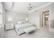 Bright bedroom features a tray ceiling, modern light fixture, and an ensuite bathroom at 13867 Vadini St, Venice, FL 34293