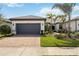 Charming single-story home with a tile roof, brick driveway, well-kept lawn, and tropical landscaping at 13867 Vadini St, Venice, FL 34293