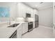 Modern kitchen with white cabinets, stainless steel appliances, and a corner sink with a sleek faucet at 13867 Vadini St, Venice, FL 34293