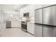 Bright kitchen with stainless steel appliances, white cabinetry and an adjacent breakfast bar at 13867 Vadini St, Venice, FL 34293