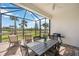 Screened lanai featuring outdoor dining set and beautiful backyard views at 13867 Vadini St, Venice, FL 34293