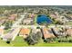 Expansive aerial view of community homes, showcasing a tranquil pond and lush greenery around residential area at 161 Valencia Lakes Dr, Venice, FL 34292