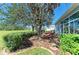 Backyard featuring manicured landscaping, a seating area, and a large shade tree at 161 Valencia Lakes Dr, Venice, FL 34292