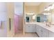 Bright bathroom with double vanity, framed mirror, and tiled shower and flooring at 161 Valencia Lakes Dr, Venice, FL 34292
