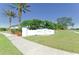 A well-maintained sign for Valencia Lakes set against a lush green landscape with palm trees and blue sky at 161 Valencia Lakes Dr, Venice, FL 34292