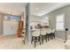 Breakfast bar with seating and open view into kitchen with white cabinets, stainless appliances and tile flooring at 161 Valencia Lakes Dr, Venice, FL 34292
