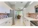 Bright open kitchen with white cabinets, stainless appliances, tile backsplash, and view to dining room at 161 Valencia Lakes Dr, Venice, FL 34292