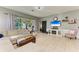 Bright living room featuring tile flooring, a comfy sofa, slider leading to a backyard, and a TV with fireplace at 161 Valencia Lakes Dr, Venice, FL 34292