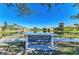 Inviting view of a calm pond from a park bench, with well-kept lawns and residences in the background at 161 Valencia Lakes Dr, Venice, FL 34292