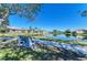 A park bench overlooking a peaceful pond surrounded by well-manicured lawns and a clear blue sky at 161 Valencia Lakes Dr, Venice, FL 34292