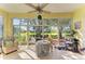 Bright sunroom with tiled floor and large windows offering beautiful backyard views at 161 Valencia Lakes Dr, Venice, FL 34292