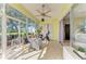 Bright sunroom with tile floor, large windows offering views of the beautifully landscaped backyard at 161 Valencia Lakes Dr, Venice, FL 34292