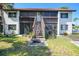 Condo exterior with wooden staircase, a screened-in patio and lush landscaping at 1636 Stickney Point Rd # 36-201, Sarasota, FL 34231