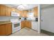 Well-lit kitchen with wood cabinets, granite counters, and modern white appliances at 1636 Stickney Point Rd # 36-201, Sarasota, FL 34231