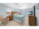 Cozy main bedroom features a king-size bed, wood dresser, and bright windows at 1636 Stickney Point Rd # 36-201, Sarasota, FL 34231