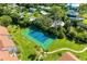 Aerial view of the community tennis court surrounded by lush landscaping at 1636 Stickney Point Rd # 36-201, Sarasota, FL 34231