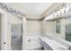 Well-lit bathroom with a garden tub, separate shower, and floral wallpaper border at 1697 San Silvestro Dr, Venice, FL 34285