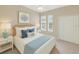 Serene bedroom featuring coastal-themed decor, plush bedding, and bright natural light at 1697 San Silvestro Dr, Venice, FL 34285