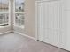 Cozy bedroom with plush carpeting, bright windows, and a spacious closet at 1697 San Silvestro Dr, Venice, FL 34285