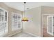 Cozy dining area featuring tile flooring, pendant lighting, and shuttered windows at 1697 San Silvestro Dr, Venice, FL 34285