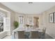Elegant dining space featuring tile floors, a white table, and a view of the backyard at 1697 San Silvestro Dr, Venice, FL 34285
