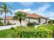 Beautiful single-story home featuring a terracotta roof, lush landscaping, and a well-maintained lawn at 1697 San Silvestro Dr, Venice, FL 34285