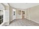 Bright living room with tile floors, shuttered window, and open doorway at 1697 San Silvestro Dr, Venice, FL 34285