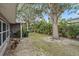 Exterior view of a lush backyard with mature trees, tropical foliage, and a well-maintained lawn at 1703 Bal Harbour Dr # 2, Venice, FL 34293