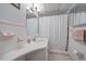 Well-lit bathroom featuring a white vanity, shower with curtain, and pink tile accents at 1703 Bal Harbour Dr # 2, Venice, FL 34293