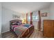 Cozy bedroom featuring a wooden bed frame, colorful bedding, and natural light from the windows at 1703 Bal Harbour Dr # 2, Venice, FL 34293