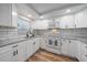 Bright kitchen featuring white cabinets, granite countertops, subway tile backsplash, and stainless steel appliances at 1703 Bal Harbour Dr # 2, Venice, FL 34293
