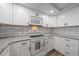 Well-lit kitchen showcasing granite countertops, subway tile backsplash, and modern appliances at 1703 Bal Harbour Dr # 2, Venice, FL 34293