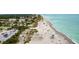 A beautiful aerial view displays the neighborhood's direct access to the sandy beach and turquoise ocean water at 19340 Bluff Dr, Venice, FL 34292