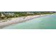 Breathtaking aerial view of the community featuring an expansive sandy beach, blue waves, and a sunny coastline at 19340 Bluff Dr, Venice, FL 34292