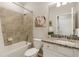 Well-lit bathroom with a shower-tub combo and a granite-topped vanity with white cabinets at 19340 Bluff Dr, Venice, FL 34292