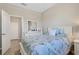 Bright bedroom with a bed with floral bedding, a dresser, and a doorway at 19340 Bluff Dr, Venice, FL 34292