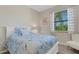 Bedroom with a bed with floral bedding, a window, and a chair at 19340 Bluff Dr, Venice, FL 34292
