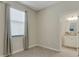 Neutral toned bedroom with a window with curtains and a doorway to the bathroom at 19340 Bluff Dr, Venice, FL 34292