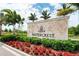 Elegant Watercrest community sign surrounded by lush landscaping and vibrant red flowers at 19340 Bluff Dr, Venice, FL 34292