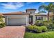 Charming single-story home features a red tile roof, brick paved driveway and manicured landscaping at 19340 Bluff Dr, Venice, FL 34292