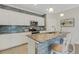Bright kitchen boasts granite island with seating, stainless appliances, and complementary blue backsplash at 19340 Bluff Dr, Venice, FL 34292