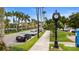 Sidewalk street view with parked cars, mature palm trees, and street lamps at 19340 Bluff Dr, Venice, FL 34292