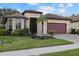 Inviting home exterior with a tile roof, lush landscaping, brick driveway, and an attached two-car garage at 20235 Pezzana Dr, Venice, FL 34292