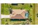 Aerial view of the house with a brown roof, pool, and lush green lawn at 205 Antis Dr, Rotonda West, FL 33947