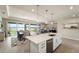 Open-concept kitchen and dining area with quartz countertops and stainless steel appliances, leading to an outdoor view at 20740 Ovid Ln, Venice, FL 34293